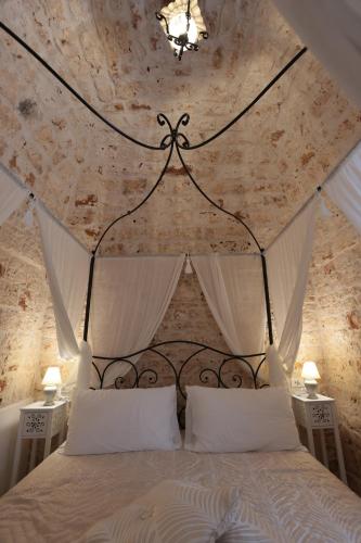 a bedroom with a large bed with a ceiling at Ántika suite & spa in Castellana Grotte