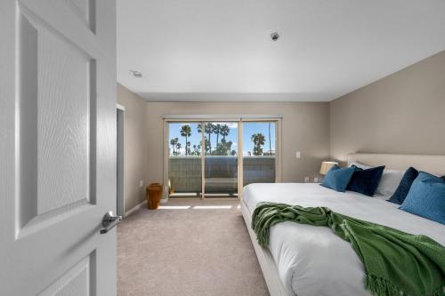 a bedroom with a large bed with blue pillows at Ocean Views - Rooftop Pool 2BR Santa Monica in Los Angeles