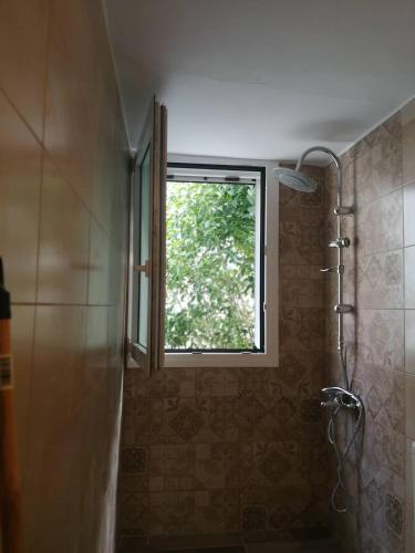 a window in a bathroom with a shower and a sink at By the sea in Astakos