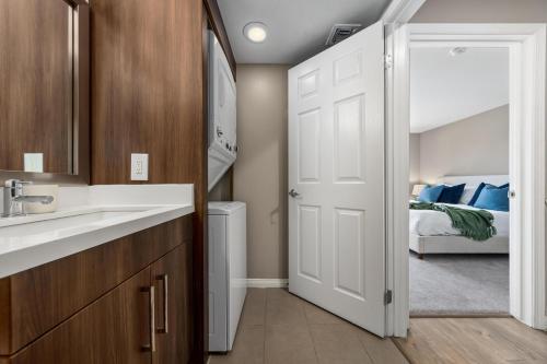 a bathroom with a sink and a door leading to a bedroom at Ocean Views - Rooftop Pool 2BR Santa Monica in Los Angeles