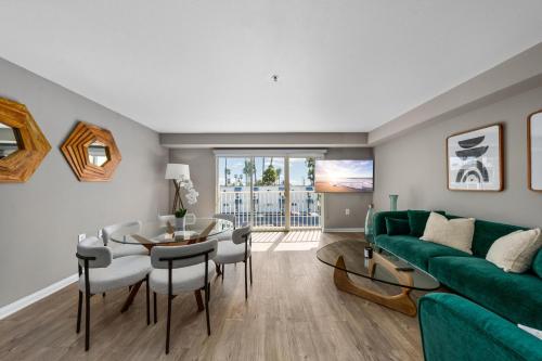 a living room with a green couch and a table at Ocean Views - Rooftop Pool 2BR Santa Monica in Los Angeles