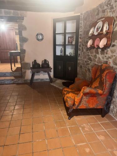 a living room with a chair and a table at Masia Can Tibau in Llagostera