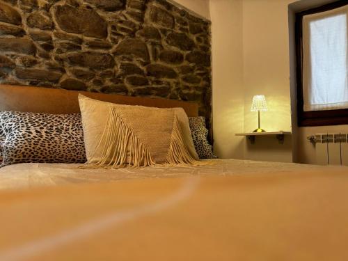 a bedroom with a bed with a stone wall at Casa Ale in Dolceacqua