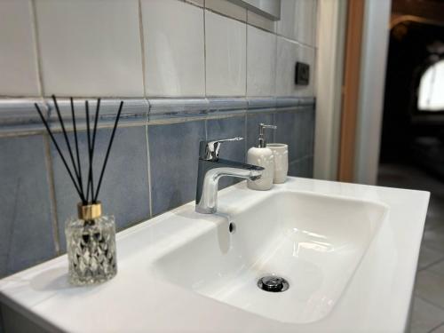 a white sink with a vase with sticks in it at Casa Ale in Dolceacqua