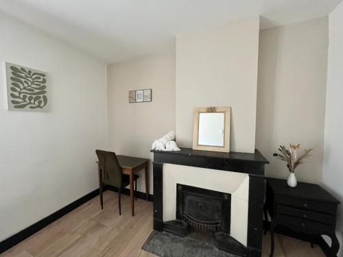 a living room with a fireplace and a mirror at Le vermeil - demeure de charme avec spa - Borne de recharge électrique in Nivolas-Vermelle