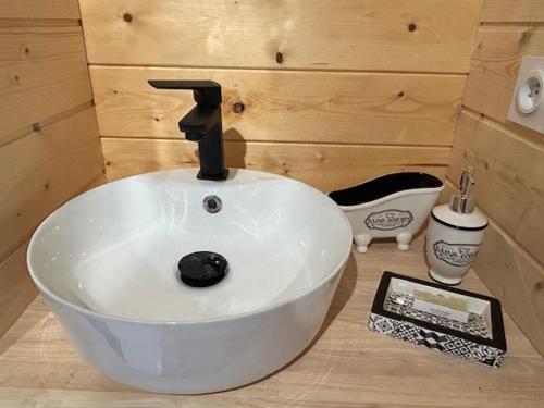 La salle de bains est pourvue d'un lavabo blanc avec un robinet. dans l'établissement Les Philous Gourmands, à LʼÉpaux