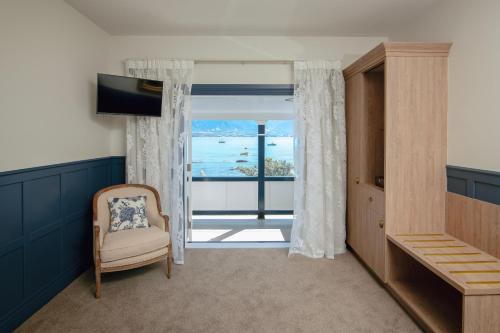 a living room with a chair and a view of the ocean at The Pier Hotel in Kaikoura