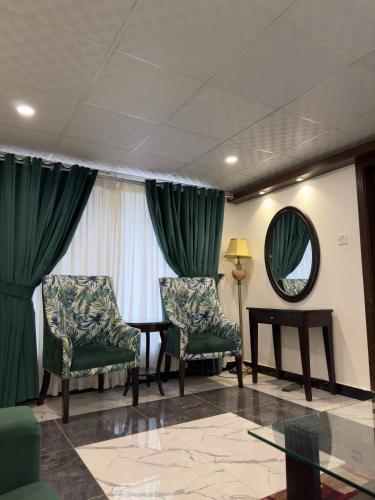 a room with two chairs and a table and a mirror at Belmont Naran in Nārān