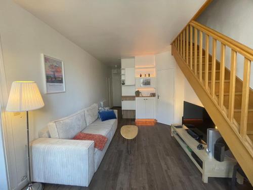 un salon avec un canapé et un escalier dans l'établissement Au cœur du marais, centre de Paris, à Paris