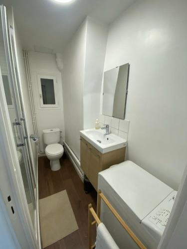 une salle de bain blanche avec des toilettes et un lavabo dans l'établissement Au cœur du marais, centre de Paris, à Paris