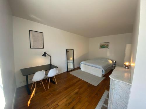 - une chambre avec un lit et un bureau dans l'établissement Au cœur du marais, centre de Paris, à Paris