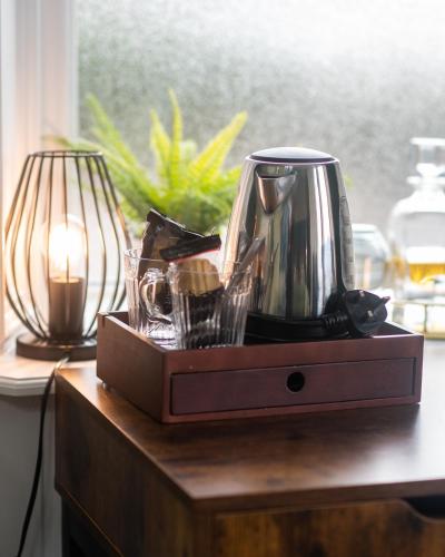 a tea kettle on top of a wooden table at Witchwood House in Oban