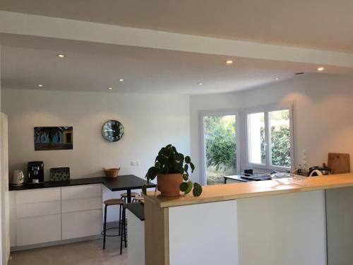 une cuisine avec des armoires blanches et un comptoir dans l'établissement Maison à deux pas de la plage, à La Celle-sous-Gouzon