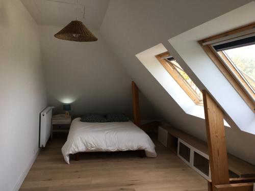 une chambre avec un lit dans un grenier dans l'établissement Maison à deux pas de la plage, à La Celle-sous-Gouzon