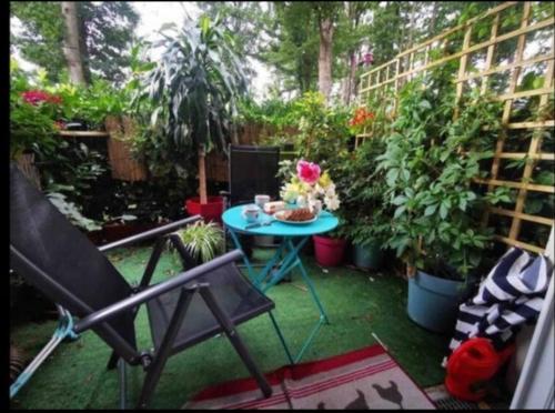 - une terrasse avec une table et un bouquet de plantes dans l'établissement Jolie Chambre, à Rambouillet