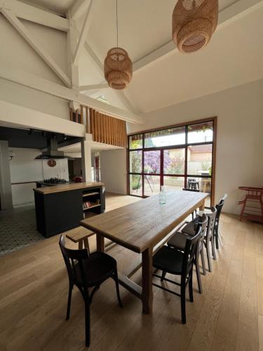 a dining room with a large wooden table and chairs at Le vermeil - demeure de charme avec spa - Borne de recharge électrique in Nivolas-Vermelle