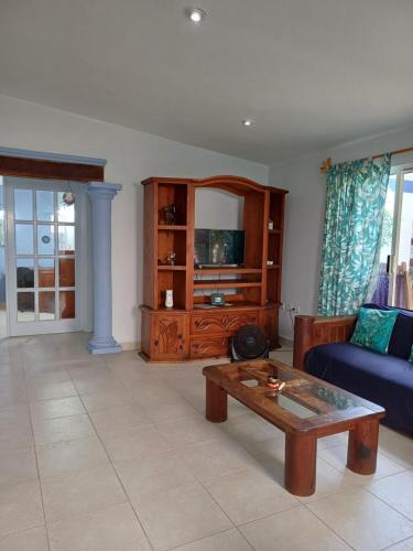 a living room with a blue couch and a coffee table at Tziimin Nahil Cozumel in Cozumel