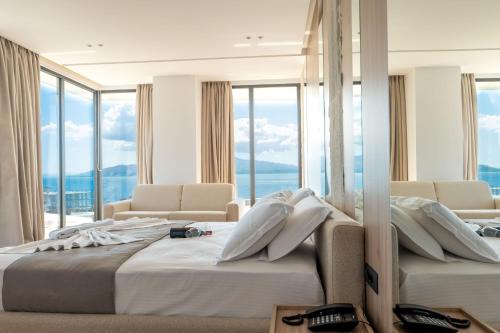 サランダにあるJako Premium Hotelのベッドが2つあり、大きな窓があるホテルの部屋