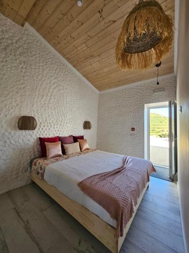 a bedroom with a large bed and a chandelier at Portugals Infinity Eco Suite Resort in Tavira