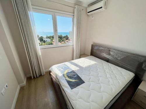a bedroom with a bed and a large window at Romantic Sunset&Seaview Apartment in Golem