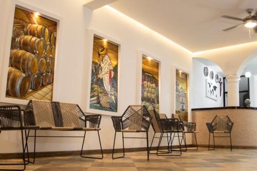 a room with chairs and paintings on the walls at Nueve Agaves Hotel in Tequila