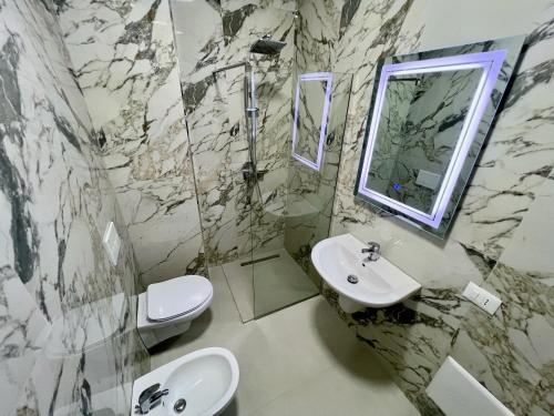 a bathroom with a sink and a toilet and a mirror at Romantic Sunset&Seaview Apartment in Golem