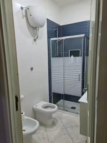 a bathroom with a toilet and a glass shower at Casadaema in Acerra