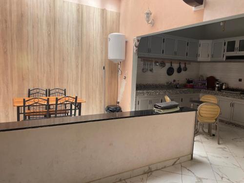 a kitchen with a counter and a table and chairs at AMAZIGH ouargaga APARTMENT in Meknès