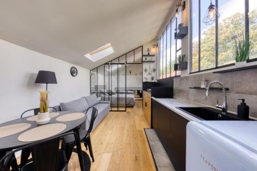 une cuisine et un salon avec une table et un canapé dans l'établissement Le Cosy Proche Paris à 5 min Métro & 10 min RER A, à Montreuil