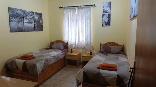 a bedroom with two beds and a desk and a window at 31 Memories in Pembroke 