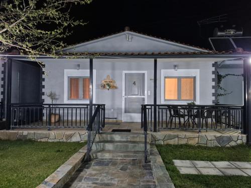 a white house with a porch and a table at Kerkini Houses in Kerkíni