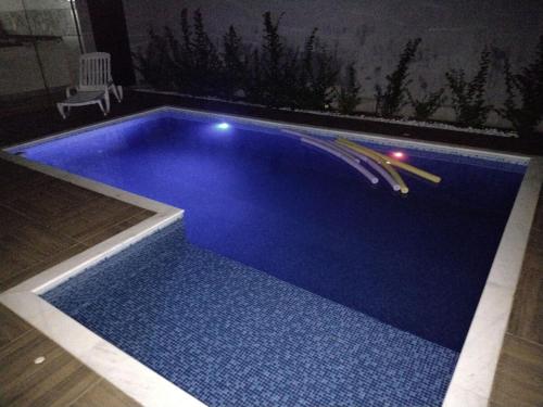 a blue swimming pool with lights in a house at Ninho Verde Holiday Home in Quadra