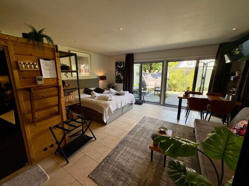 a bedroom with a bed and a room with a table at B&B Wellness Soest in Soest