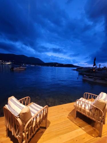 two chairs sitting on a dock next to the water at Artis Blue Relax in Himare