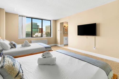 アーリントンにあるCrystal City Escape Stylish Apt Close to DC Airportのベッド2台と薄型テレビ付きのベッドルーム