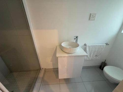 a white bathroom with a sink and a toilet at Carpe Diem in Langebaan
