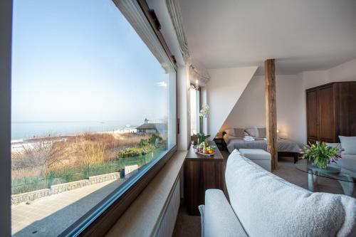 a room with a large window with a view of the ocean at COLUMBUS Apartamenty Ustka - Limanowskiego 1 in Ustka