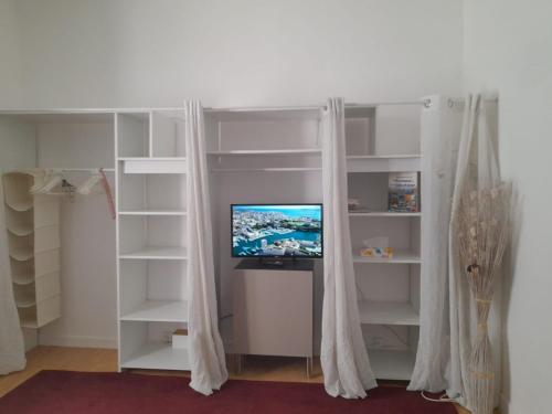 une étagère blanche avec une télévision dans l'établissement T2 Longchamp Blancarde Timone, à Marseille