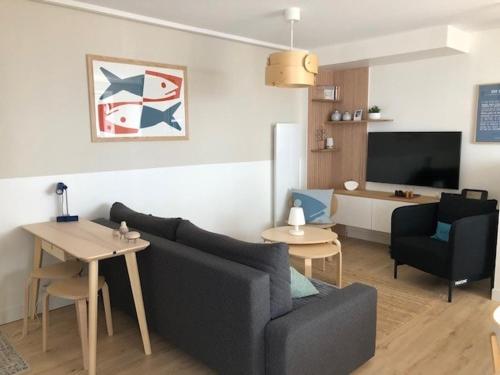 un salon avec un canapé et une table dans l'établissement PETITE MAISON à 100M DE LA MER ET DU CENTRE VILLE, à Concarneau