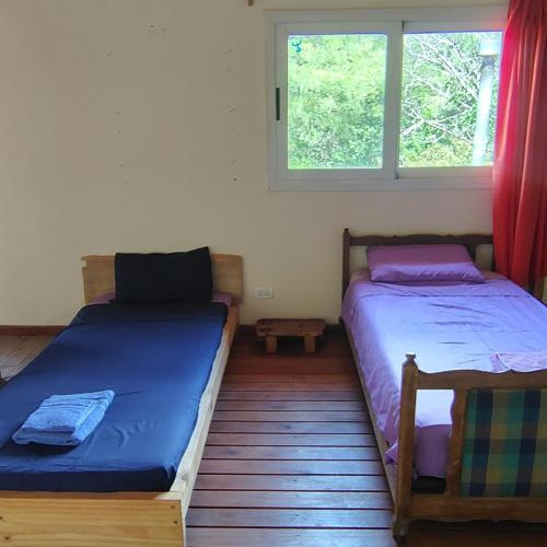 two beds in a room with a window at La Casa Azul in San Javier