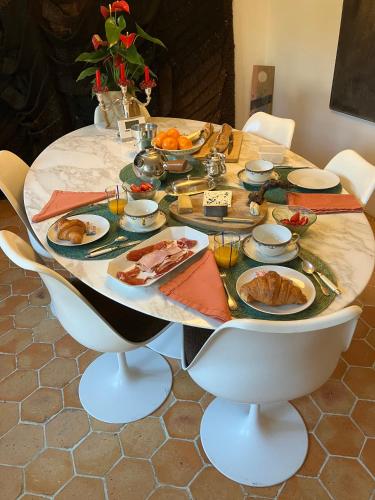une table avec des assiettes de nourriture dessus dans l'établissement La Chaumière - petit-déjeuner inclus à 15 min de Versailles, à Jouars-Pontchartrain