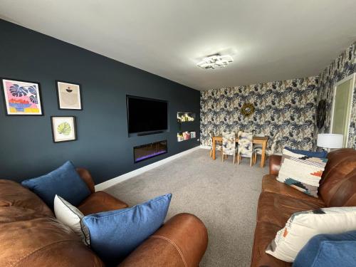 a living room with a couch and a tv at The Fireman's Bungalow in Springwell
