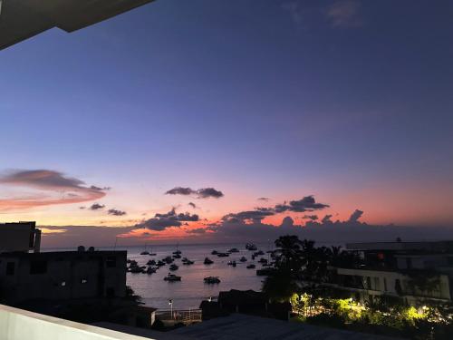 a sunset over a harbor with boats in the water at Hostal Gosén in Puerto Baquerizo Moreno