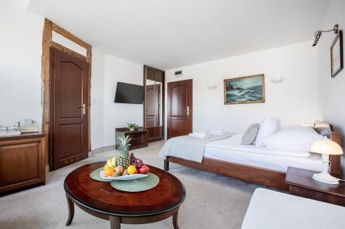 a hotel room with a bed and a table with a bowl of fruit at COLUMBUS Apartamenty Ustka - Limanowskiego 1 in Ustka