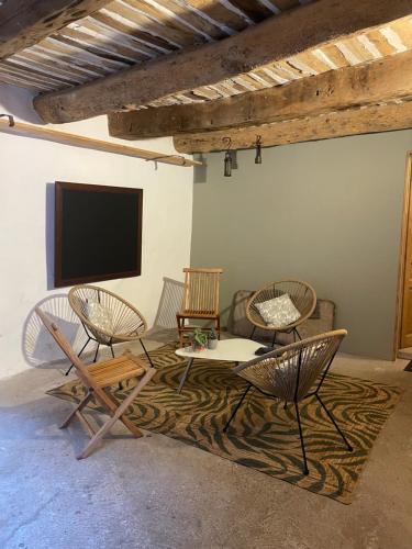 un salon avec des chaises et une télévision à écran plat dans l'établissement Room in Medieval Cereste, à Céreste