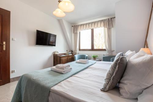a bedroom with a bed with two towels on it at COLUMBUS Apartamenty Ustka - Limanowskiego 1 in Ustka