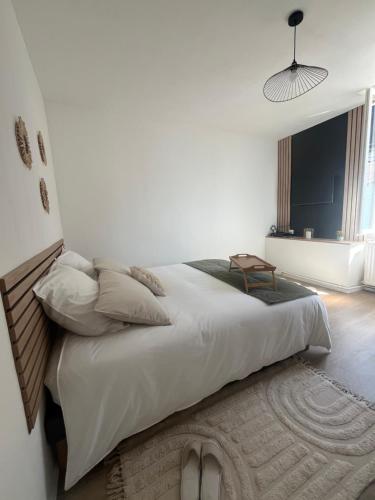 - une chambre avec un grand lit aux murs blancs dans l'établissement La P'tite Maison D'Auron, à Bourges