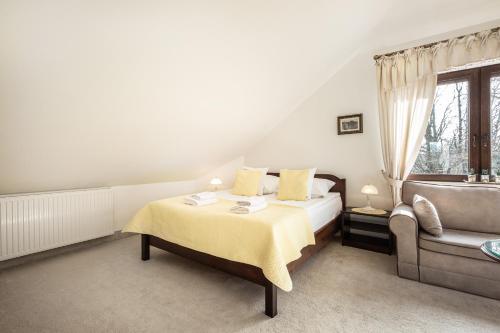 a bedroom with a bed and a couch at COLUMBUS Apartamenty Ustka - Limanowskiego 1 in Ustka