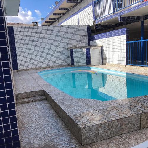 a swimming pool in a house with a tile wall at Pousada do Bene - Aluguel Casa in Guarujá