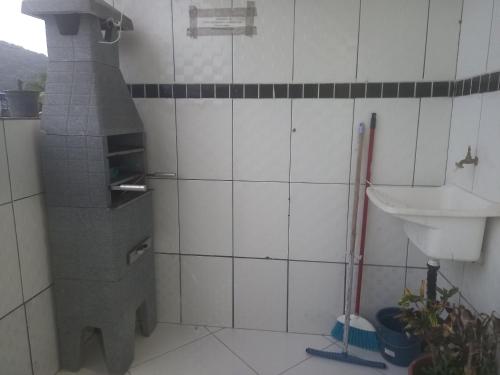a kitchen with a pizza oven and a sink at Pousada do Bene - Aluguel Casa in Guarujá
